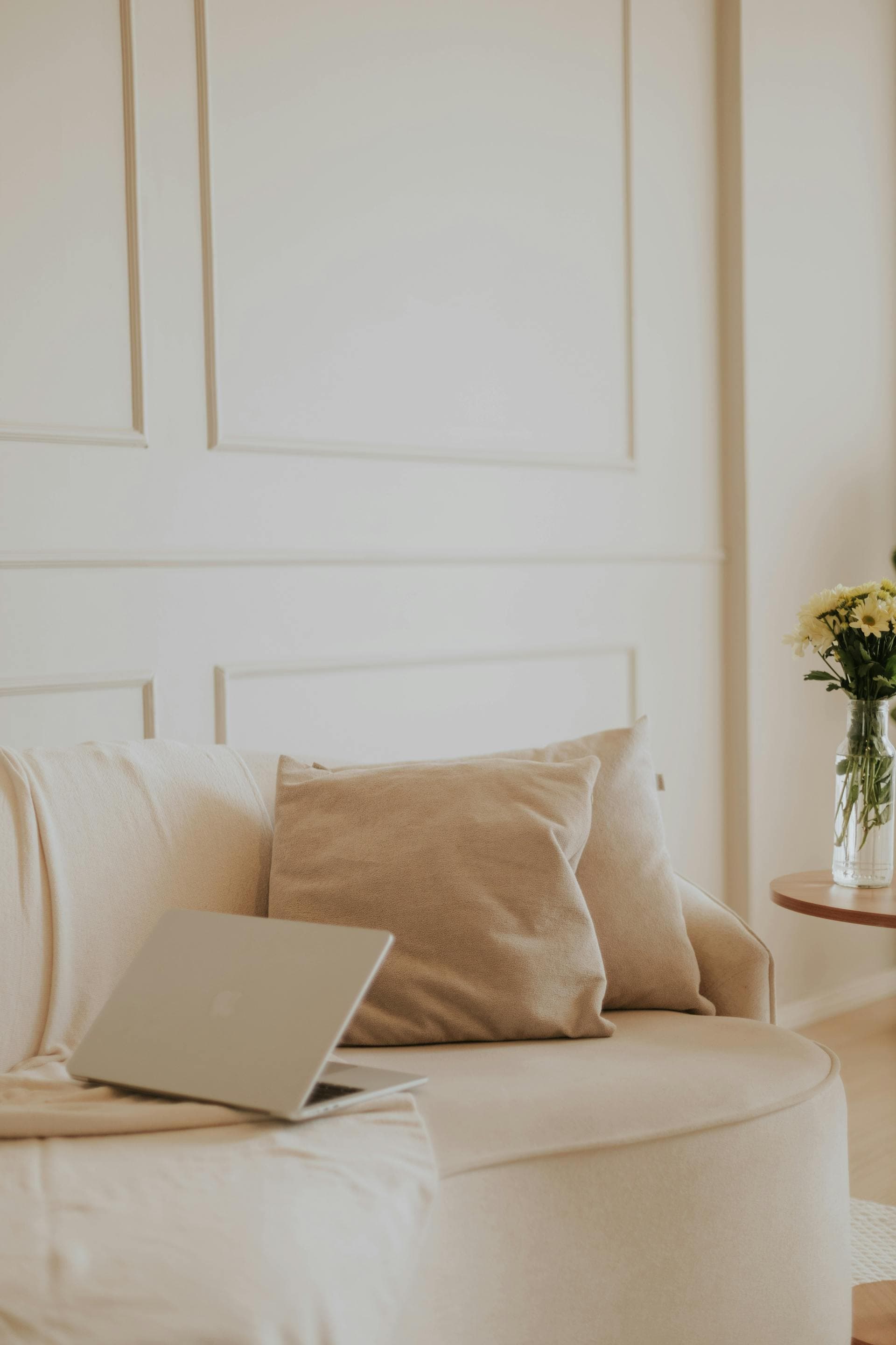 Moderner Remote-Arbeitsplatz mit Laptop auf einem beigen Sofa; repräsentiert die agile Webentwicklung für Next.js Projekte von überall aus.